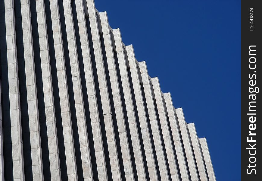 A repeating pattern of black and white columns against a blue sky.