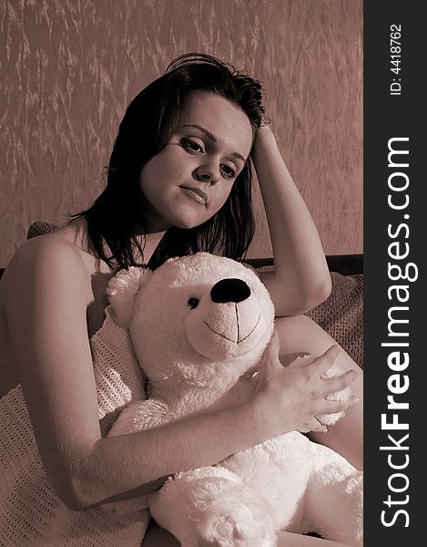 Beautiful girl with a toy bear. Sepia