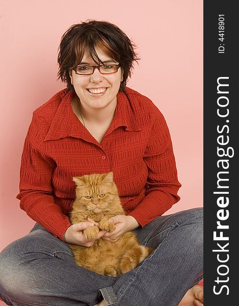 Young beautiful woman holding a domestic red cat