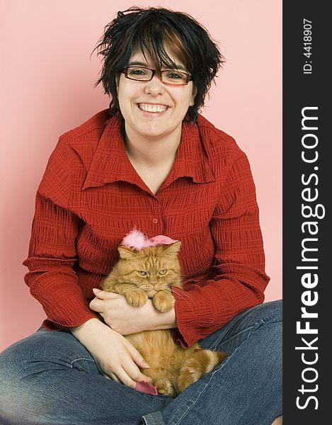 Young beautiful woman holding a red domestic cat