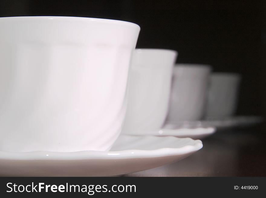 Some white tea cups on a black background