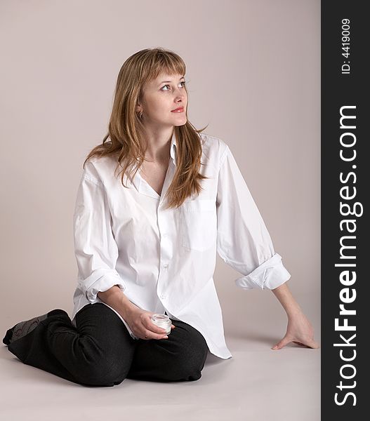 An image of nice girl sitting on neutral background. An image of nice girl sitting on neutral background
