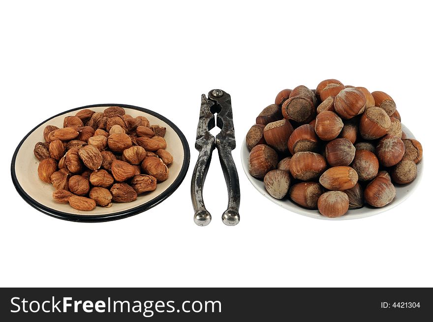 Filbert and nuts on plates with old cracker, isolated on white.