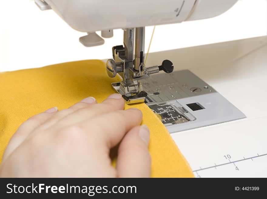Sewing machine and yellow fabric isolated on white
