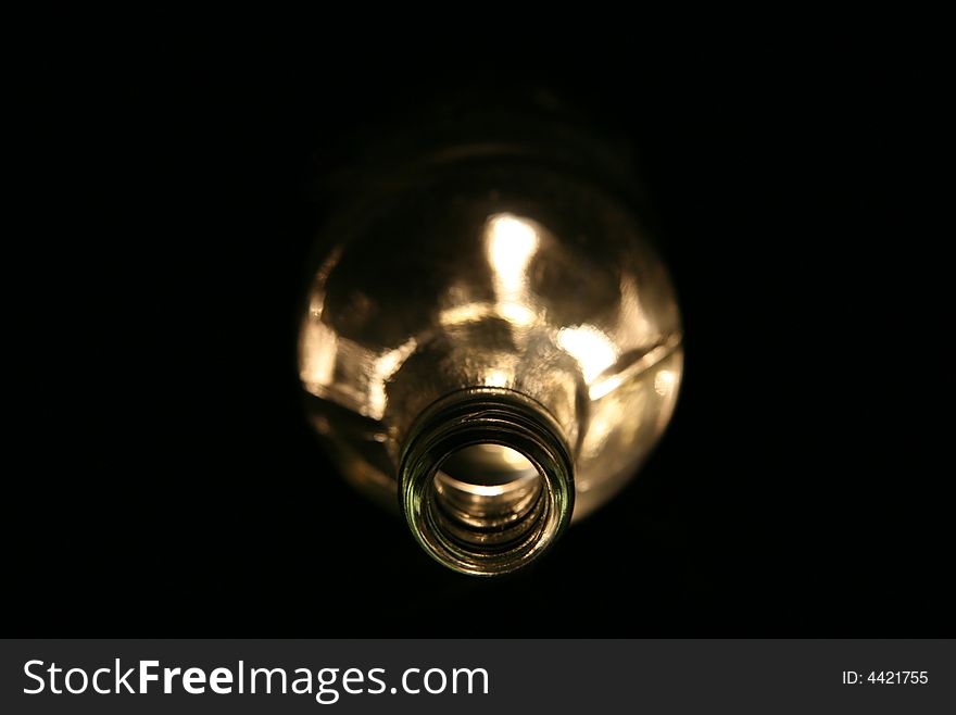 Empty glass bottle lying in the dark with spooky light. Empty glass bottle lying in the dark with spooky light