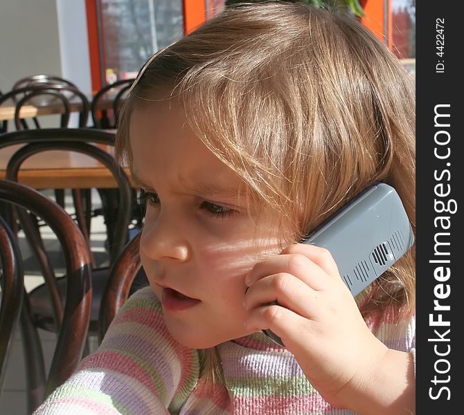 Kid having a telephone call at a cafe