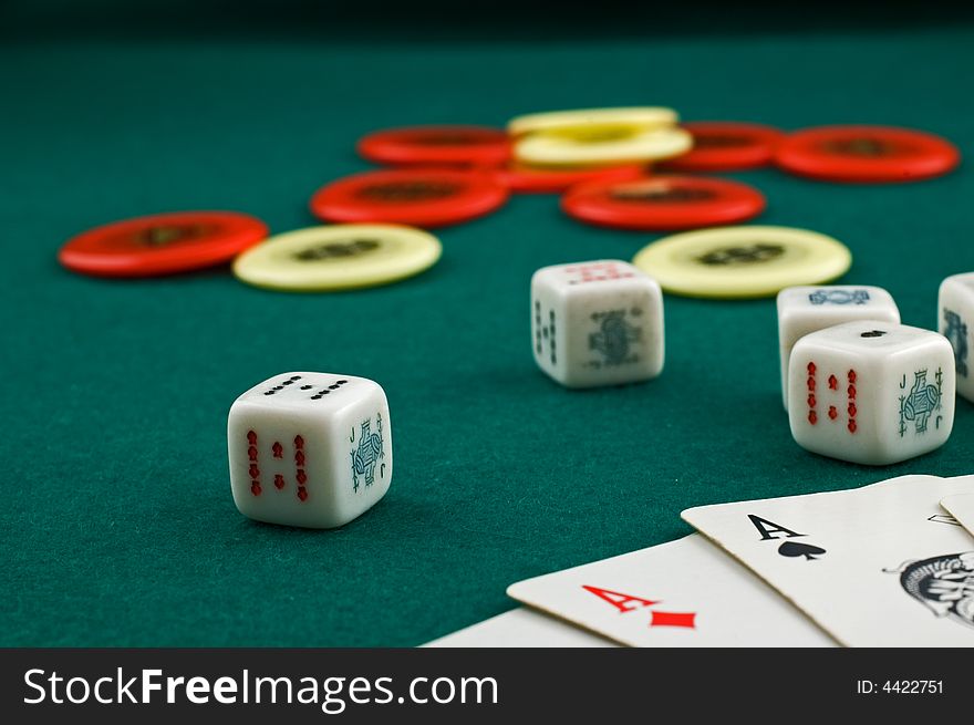 Dice, cards and chips on green carpet with selective focus