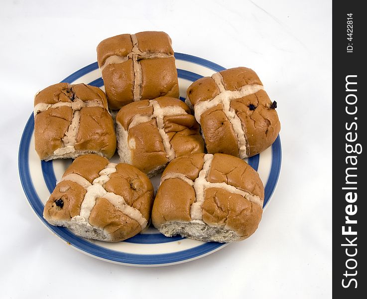 Home made Hot Cross Buns on a plate on a white background. The bun marks the end of Lent and different parts of the hot cross bun have a certain meaning, including the cross representing the crucifixion of Jesus, and the spices inside signifying the spices used to embalm him at his burial. They are now available all year round in some places. Hot cross buns are rich with history, dating back to the 12th century. They&#x27;re yeasted sweet buns filled with spices and various fruits such as currants, raisins, and/or candied citrus. They&#x27;re decorated with a white cross, either marked right into the dough or etched on top with icing.  Why do we eat hot cross buns at Easter?  A hot cross bun is a spiced sweet bun made with currants or raisins, marked with a cross on the top, and traditionally eaten on Good Friday. The eating of hot cross buns marks the end of Lent because they are made with dairy products which are forbidden during this period. Home made Hot Cross Buns on a plate on a white background. The bun marks the end of Lent and different parts of the hot cross bun have a certain meaning, including the cross representing the crucifixion of Jesus, and the spices inside signifying the spices used to embalm him at his burial. They are now available all year round in some places. Hot cross buns are rich with history, dating back to the 12th century. They&#x27;re yeasted sweet buns filled with spices and various fruits such as currants, raisins, and/or candied citrus. They&#x27;re decorated with a white cross, either marked right into the dough or etched on top with icing.  Why do we eat hot cross buns at Easter?  A hot cross bun is a spiced sweet bun made with currants or raisins, marked with a cross on the top, and traditionally eaten on Good Friday. The eating of hot cross buns marks the end of Lent because they are made with dairy products which are forbidden during this period.