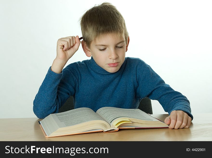 Little boy read book and scratch one's head