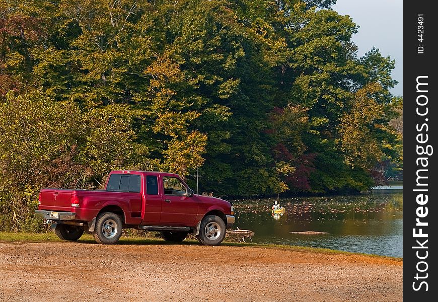 A truck and a lone man fishing on a quiet lake in New Jersey. A truck and a lone man fishing on a quiet lake in New Jersey.