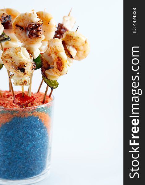 Shrimp skewers covered in a glass of colored salts. Shrimp skewers covered in a glass of colored salts
