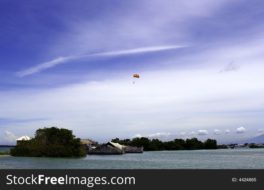 A man parasailing above a small fishing village