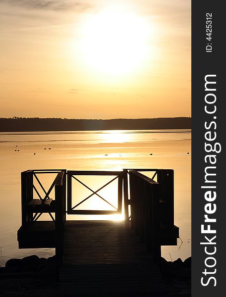 Beautiful sunrise with bridge in silhouette in front of water