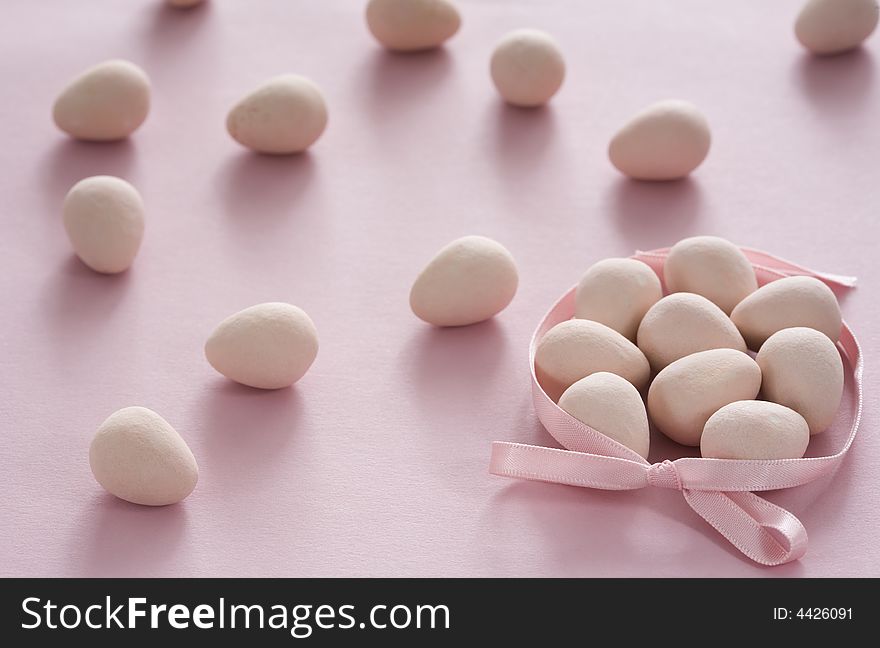 Pink egg-shaped coated chocolate candies with pink ribbon for Easter. Pink egg-shaped coated chocolate candies with pink ribbon for Easter