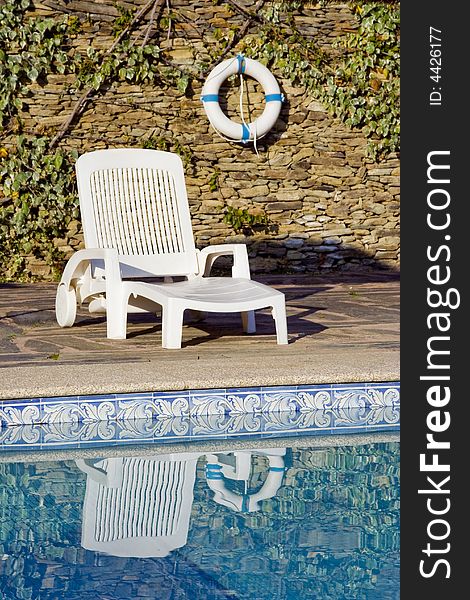 A buoy and a white deckchair near the swimming pool