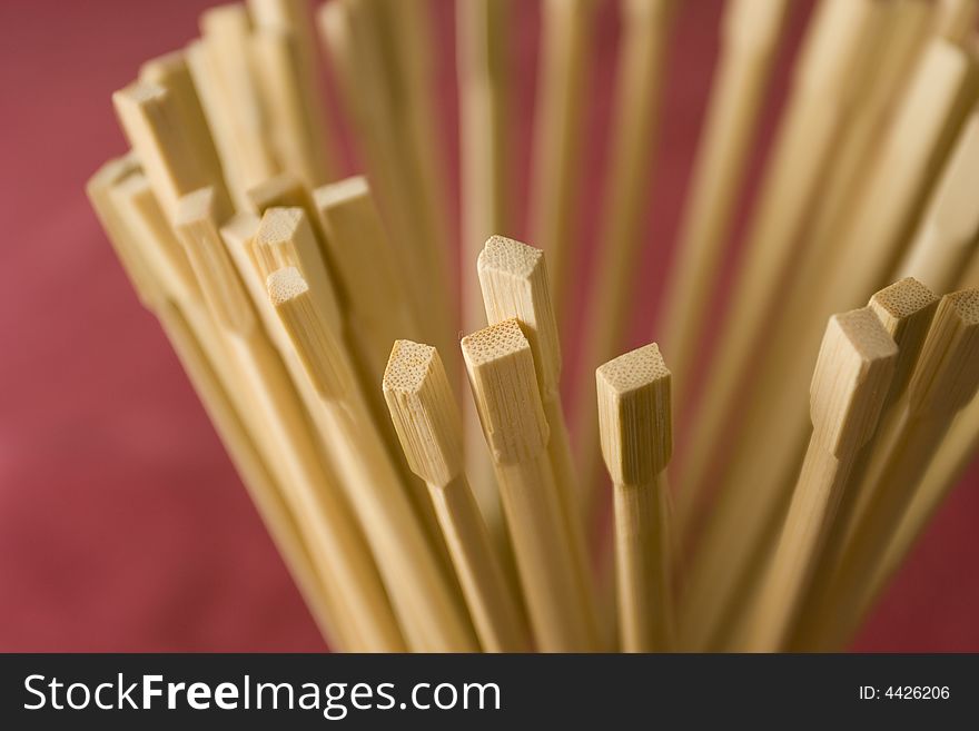 Chopsticks in the glass on red textile background