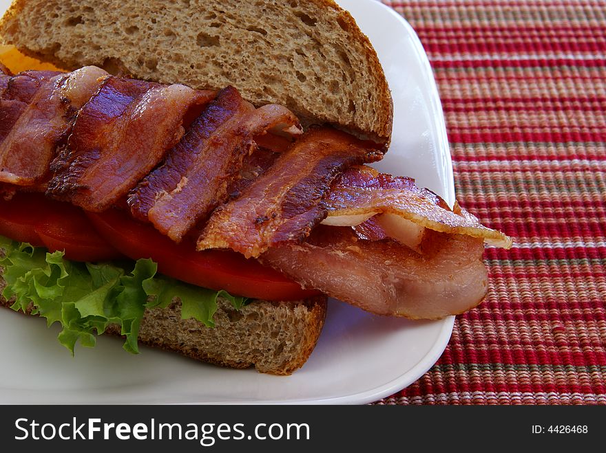 Bacon, Lettuce, and Tomato (BLT) on rustic whole grain loaf bread with chips. Bacon, Lettuce, and Tomato (BLT) on rustic whole grain loaf bread with chips.