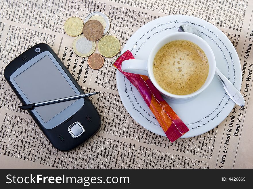 Cellphone, money and coffee over newspaper -business concept