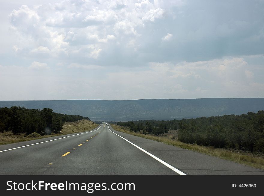 A Mid-west USA road taking me to the mountains in the middle of the vegetation. A Mid-west USA road taking me to the mountains in the middle of the vegetation