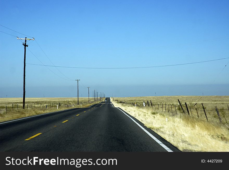 A road cross Nevada (USA) and seems to disappear behind the horizon. A road cross Nevada (USA) and seems to disappear behind the horizon