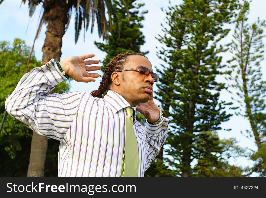 Businessman stretching with arms by his head.