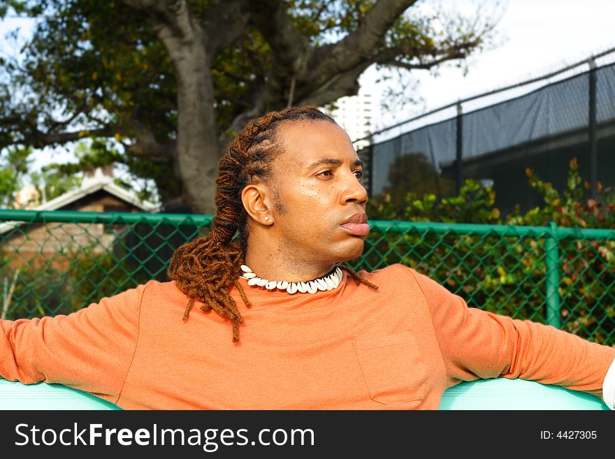 Man casually sitting on a bench. Man casually sitting on a bench