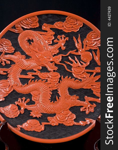 Decorative carved saucer with red dragon on black. Decorative carved saucer with red dragon on black