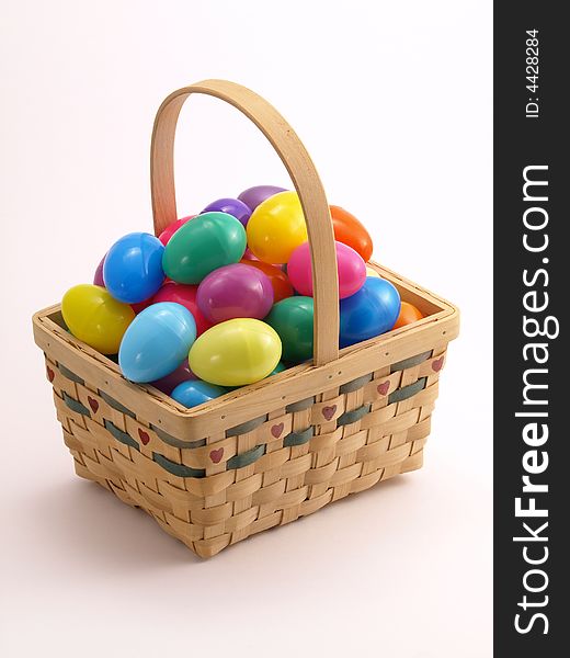 Wicker Easter Basket full of colorful eggs. Wicker Easter Basket full of colorful eggs