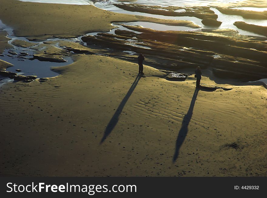 Two men stand on the beach. Two men stand on the beach