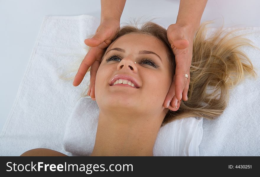 Masseuse does relax facial massage to the girl