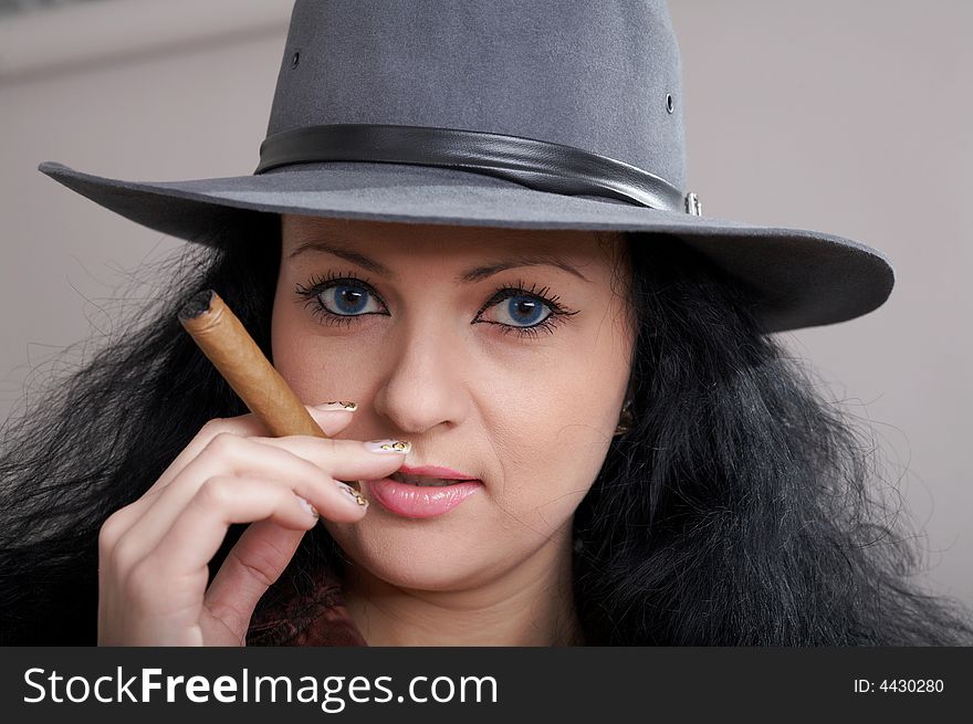 An image of a nice woman in felt hat with cigar. An image of a nice woman in felt hat with cigar