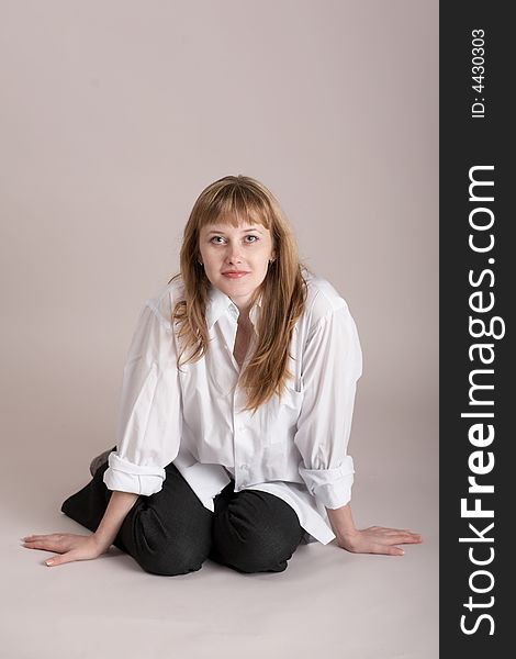 An image of nice woman sitting on neutral background. An image of nice woman sitting on neutral background