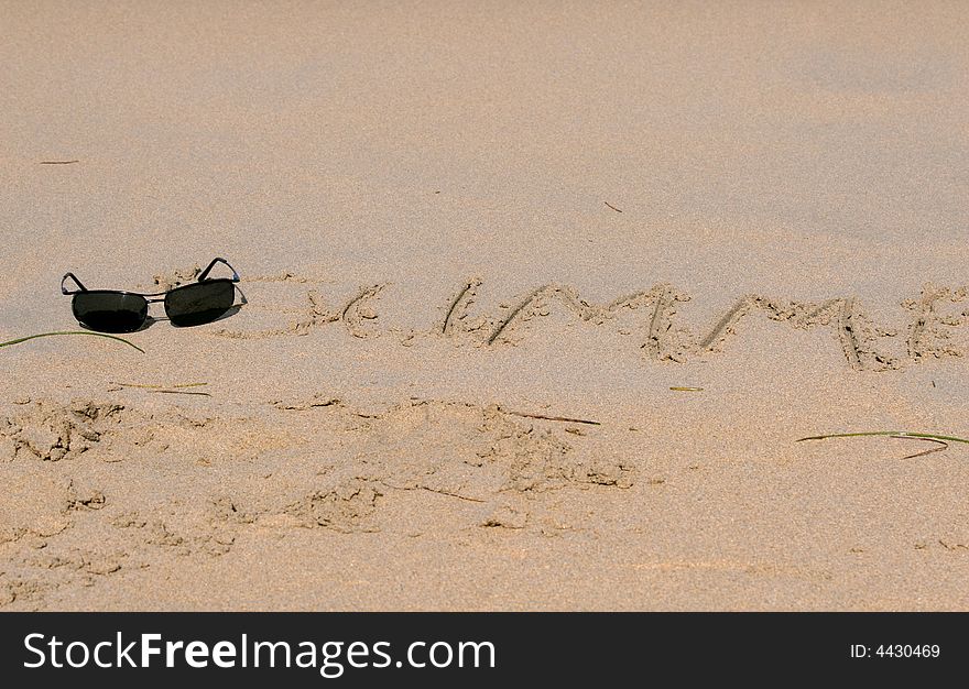 Sand writing on the beach with sunglasses. Sand writing on the beach with sunglasses