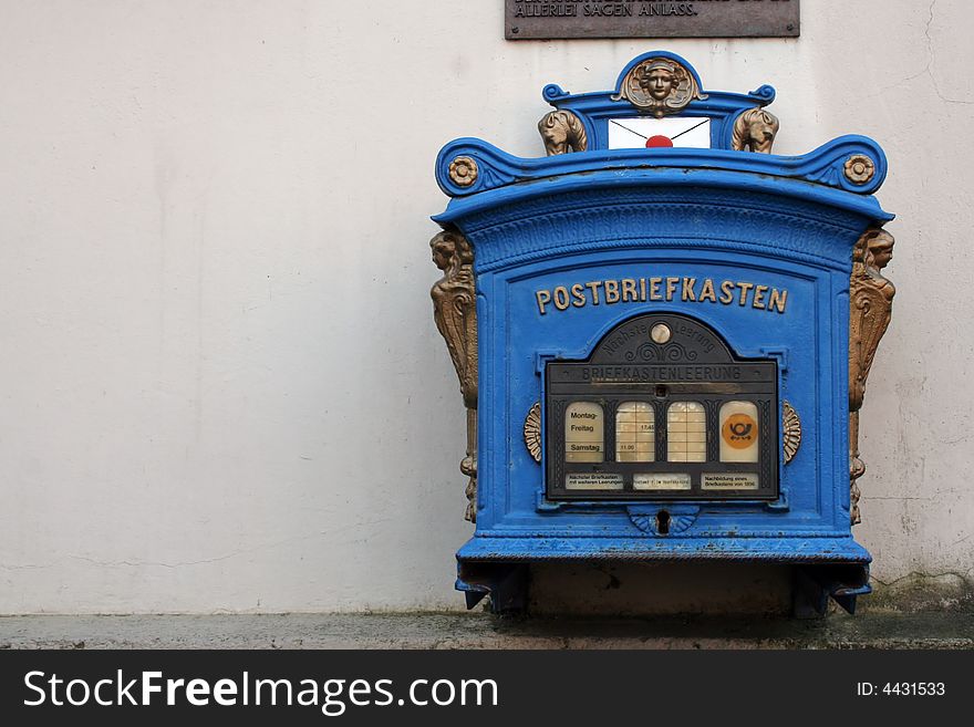 Old German mailbox. It is blue with gold accents.