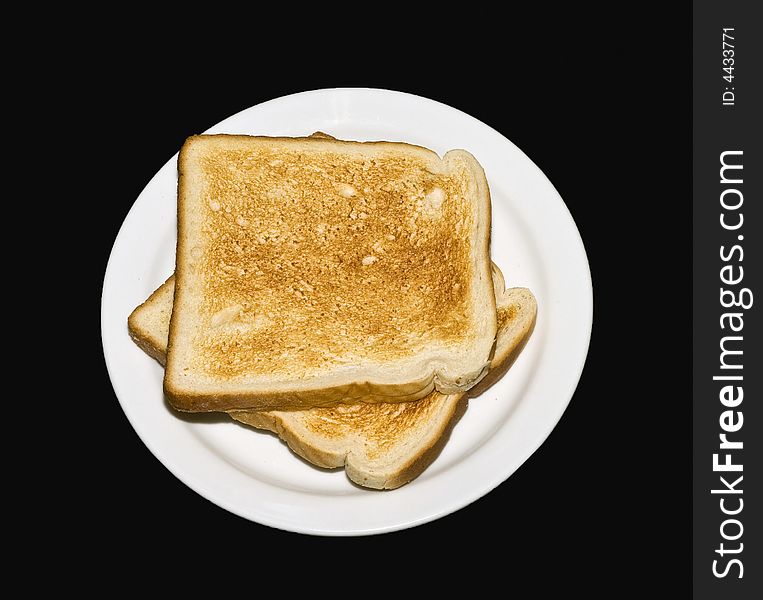 Two tosts on white plate with black background