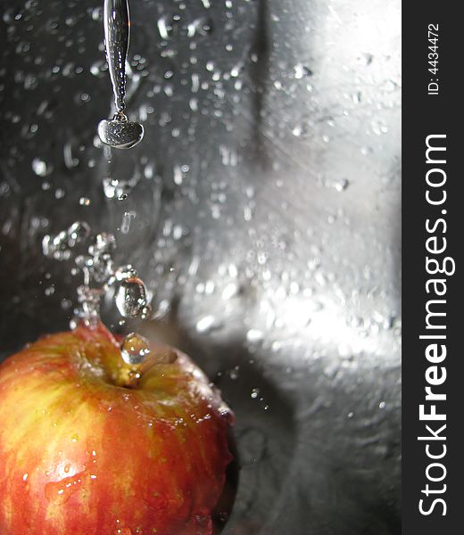 Apple with water splashing off it