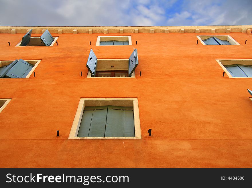 Orange Wall with open and closed green shutters in Venice. Orange Wall with open and closed green shutters in Venice