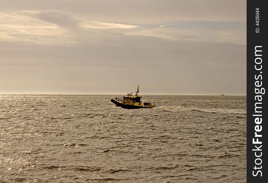 A pilot boat heading out of the harbor in the dawn light. A pilot boat heading out of the harbor in the dawn light