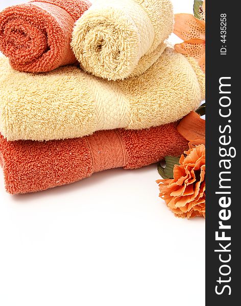 Beautiful bath ensemble with wash cloths and towels in burnt orange and sand colors on white.