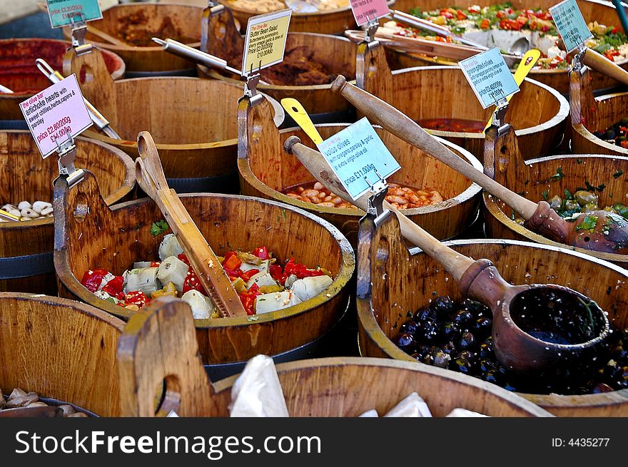 Olives for sale in wooden tubs at a market stall. Olives for sale in wooden tubs at a market stall