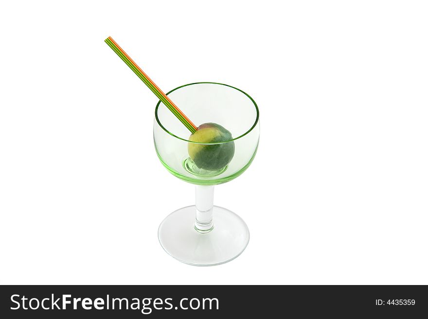 Round green and yellow bonbon with stick inside glass isolated over white