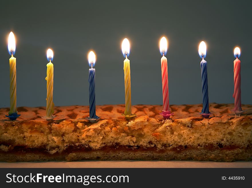 Burning color candles on a celebratory pie