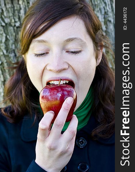 Young woman bitting an apple