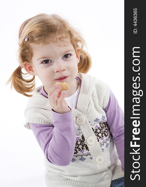 Cute little girl eating cookie
