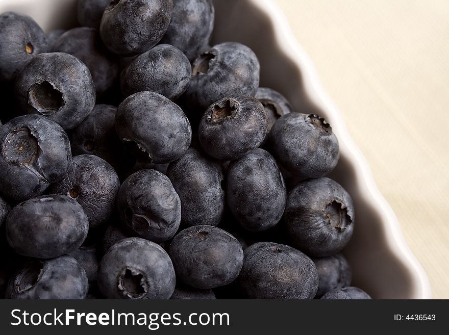 A white cup full of fresh ripe blueberries. A white cup full of fresh ripe blueberries