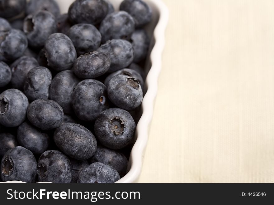 A white cup full of fresh ripe blueberries. A white cup full of fresh ripe blueberries