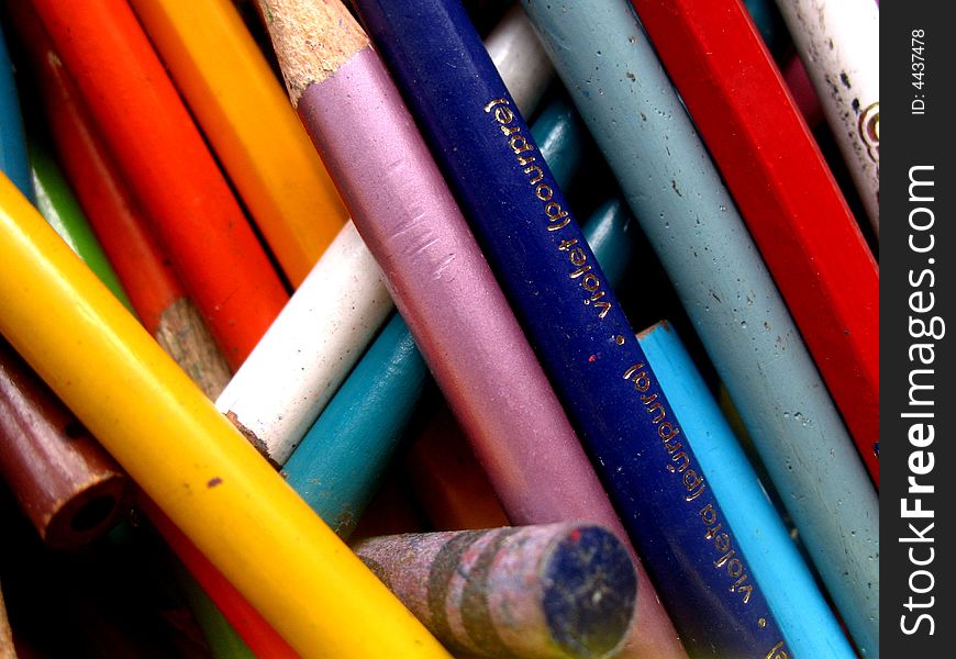 Jumbled up collection of old coloring pencils. Close up, full-frame shot