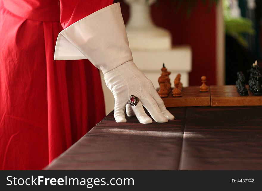 It's a riddle. Ren hand, white glove red gem and chess are from famous book. It's a riddle. Ren hand, white glove red gem and chess are from famous book.