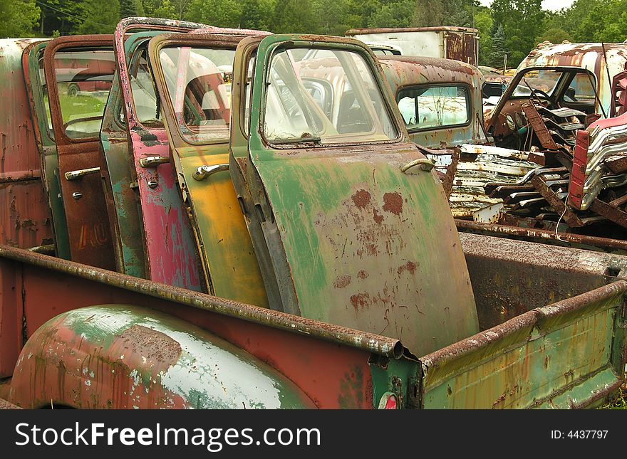 Old car doors in the back of a rusty pickup truck. Old car doors in the back of a rusty pickup truck