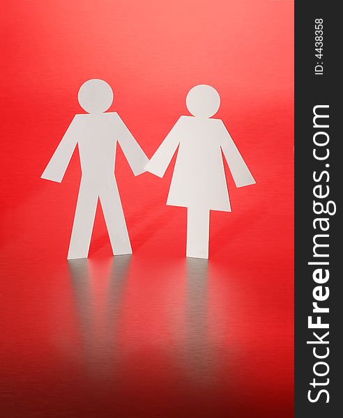 Paper cut-outs of a man and woman on a red background. Paper cut-outs of a man and woman on a red background